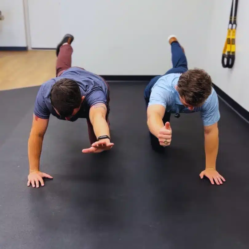 Dr. Seth Little and patient performing bird dog core exercise for spine and balance rehab in Fort Worth.