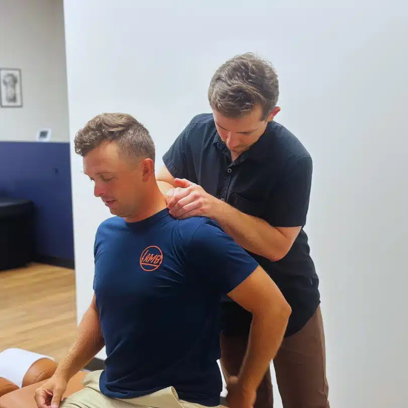 Chiropractor performing myofascial release on patient’s upper back and shoulders in Fort Worth, TX.