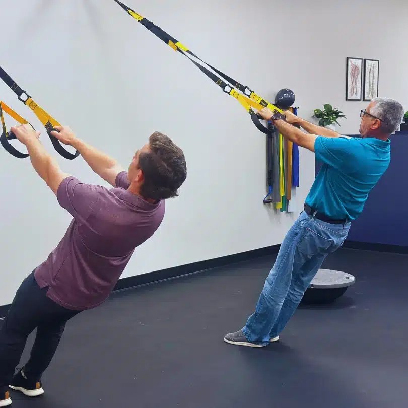 Functional rehab using TRX suspension bands at Limitless Chiropractic in Alliance.